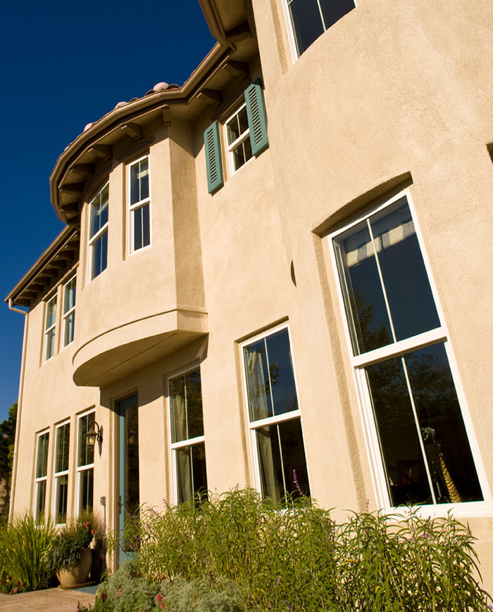 Two-story stucco house with many vinyl windows