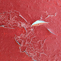 Chipped red paint on old door - close up