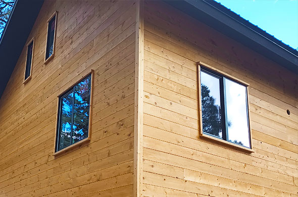 Windows on a wood-paneled house exterior