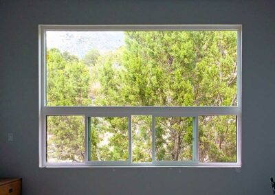 Large picture window with pinion trees outside