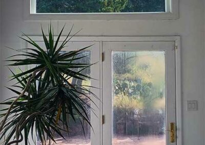 Large picture window above glass patio doors looking at the Sandia mountains